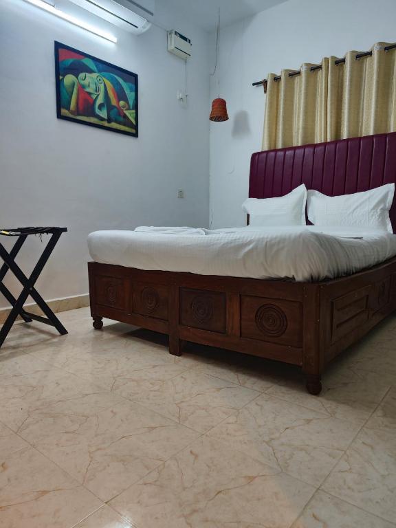 a bed in a room with a wooden frame at Quiet Coastal Hideaway Studio near Candolim Beach in Candolim