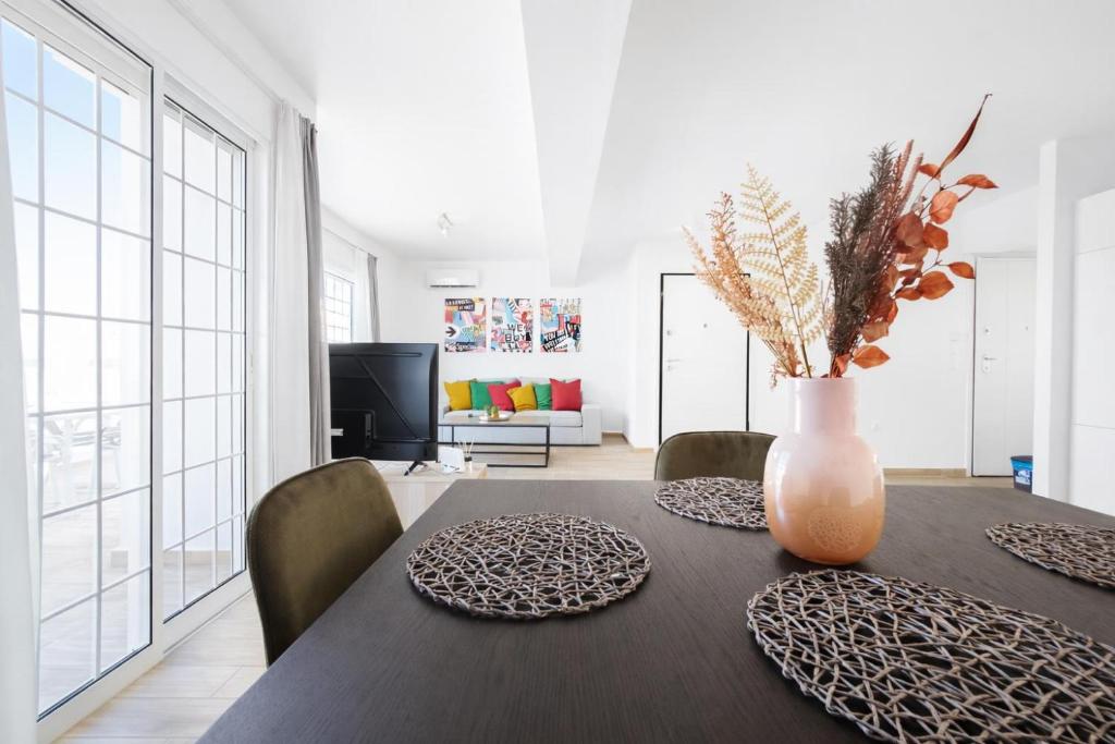 a dining room table with two plates and a vase with flowers at Andromaches by Verde Apartments in Athens
