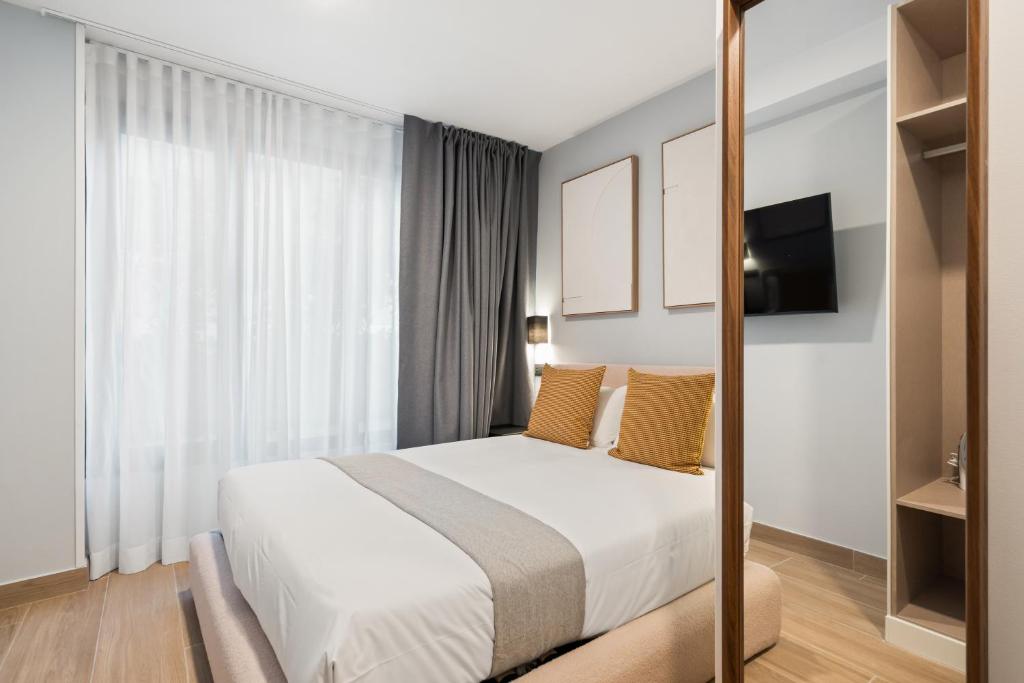 a hotel room with a bed and a television at Dobo Madrid Portugal in Madrid
