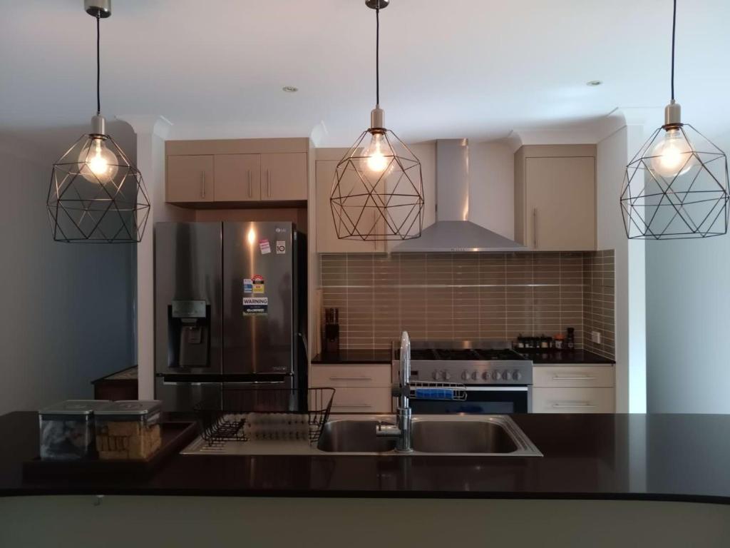 een keuken met een spoelbak en een koelkast bij Victoria Point Queen bed & Breakfast in Victoria Point