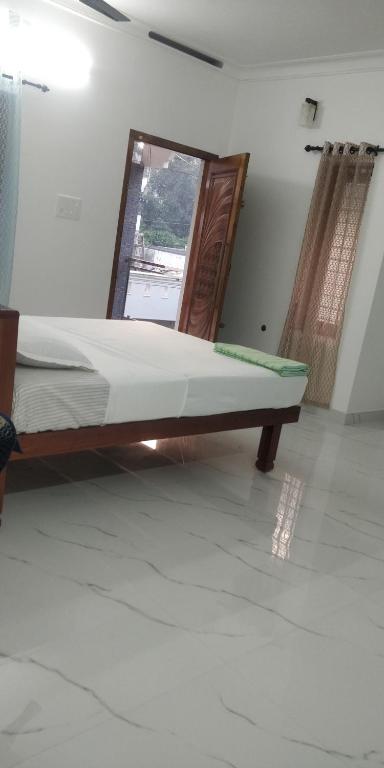 a bed sitting in a room with a mirror at Temple House in Trivandrum
