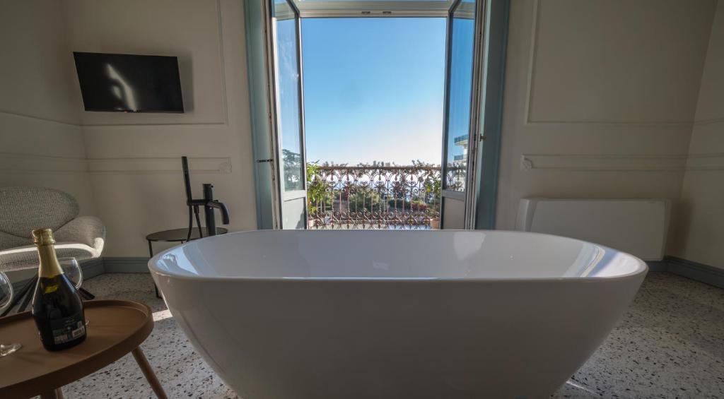 een wit bad in een kamer met een raam bij Des Bains Acireale in Acireale