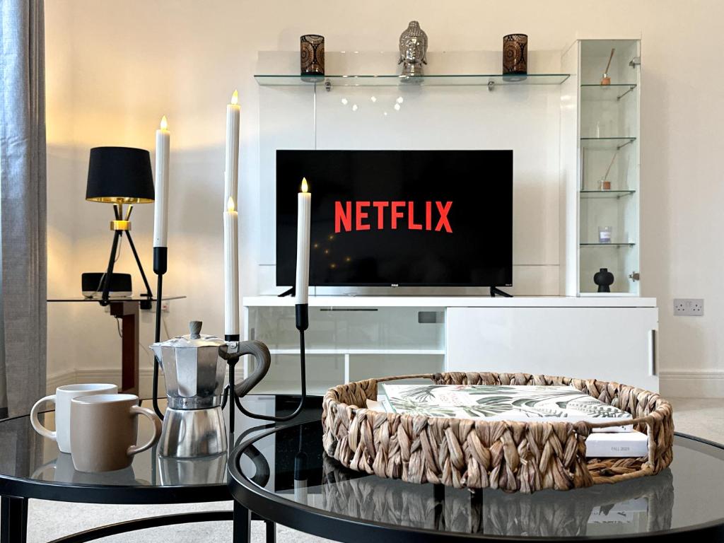 ein Wohnzimmer mit Fernseher und Couchtisch in der Unterkunft Heathrow Home - 4BR - Sleeps 6 - Free Parking - Work and Family Friendly in Stanwell