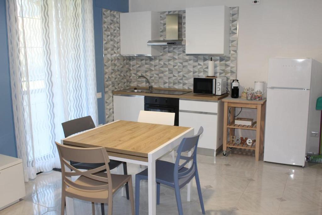 eine Küche mit Tisch und Stühlen und einem Kühlschrank in der Unterkunft Il Poeta - casa accogliente tra Amalfi e Cilento in Battipaglia