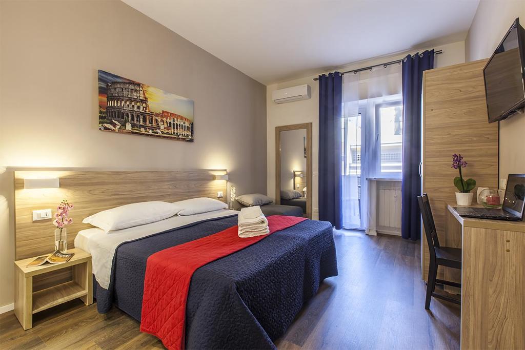 una camera d'albergo con un letto con una coperta rossa e blu di La Palma a Roma