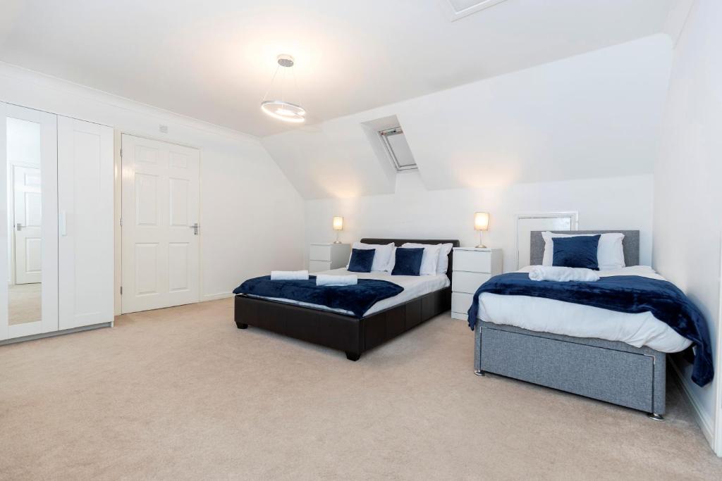 twee bedden in een slaapkamer met witte muren bij Spacious 3-Bed Home – Family Contractor Friendly in Coxhoe