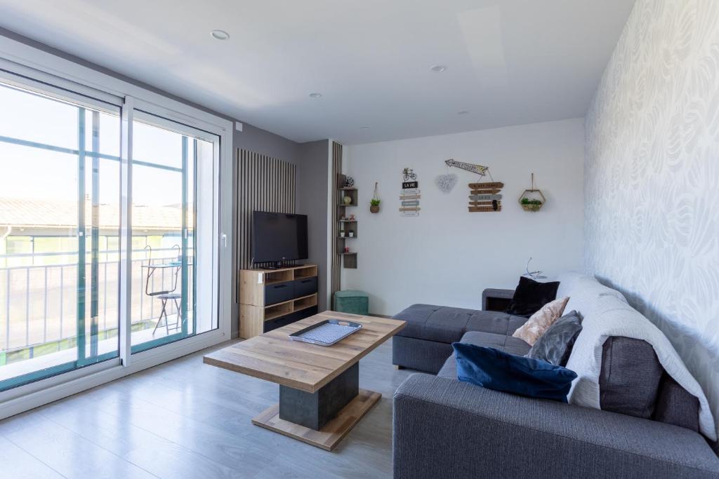 ein Wohnzimmer mit Sofa und Tisch in der Unterkunft Cocon Savinois - Vue Montagne in Savines