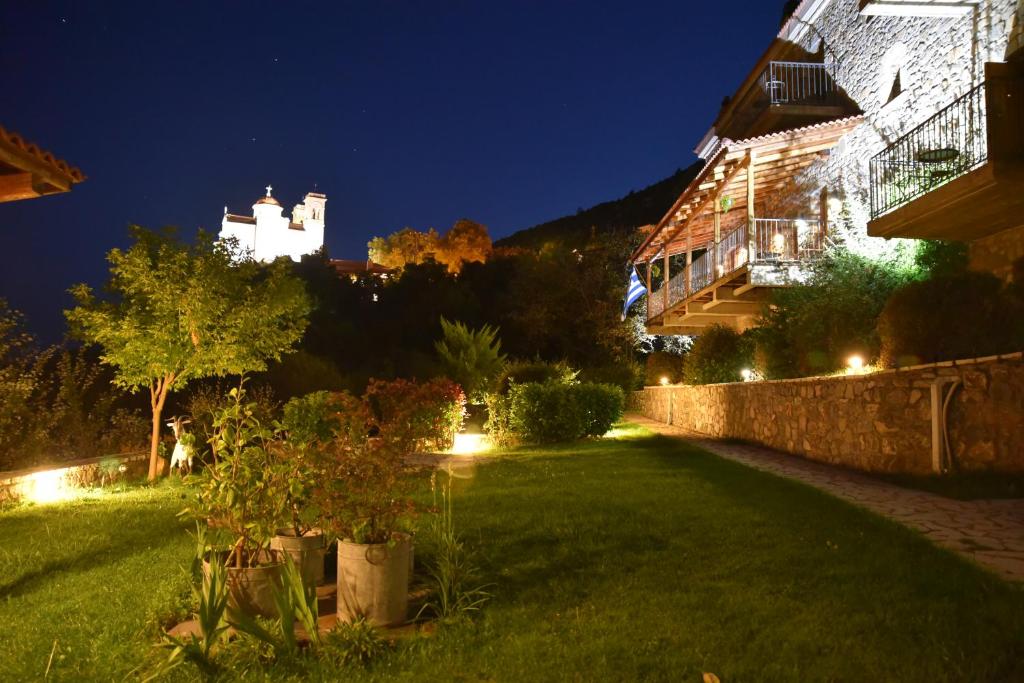 un jardín por la noche con un castillo en el fondo en Hotel Papanikola, en Piána