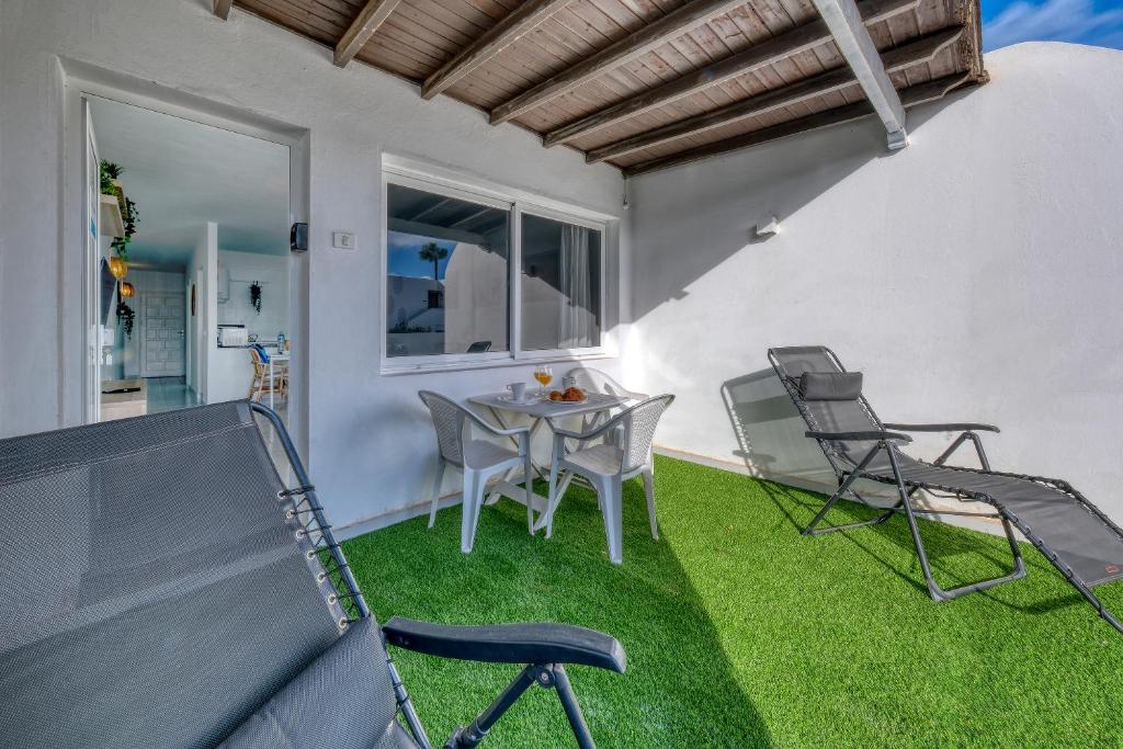 patio con tavolo e sedie sull'erba di SUITE ABORA RELAX a 500m DE LA PLAYA WIFI FIBRA a Puerto del Carmen