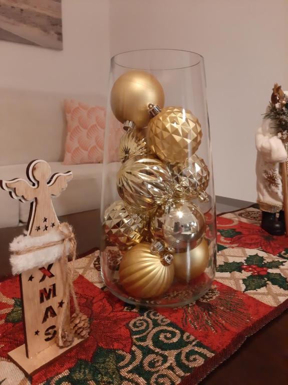 een glazen pot gevuld met kerstversieringen op een tafel bij Skyline Vista - Sea View Apartment with Free Parking in Piraeus