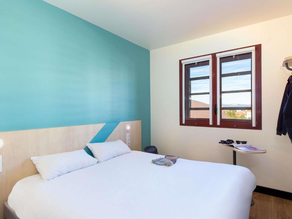 een slaapkamer met twee bedden en een raam bij ibis budget Perpignan Centre Rénové en 2025 - Hôtel Economique au Centre ville de Perpignan in Perpignan