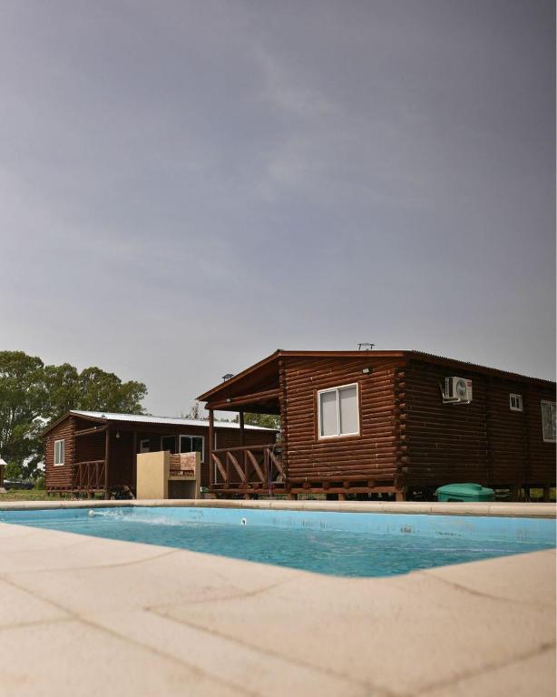 a log cabin with a pool in front of it at CABAÑAS BRUTUS RANCHs in Azul