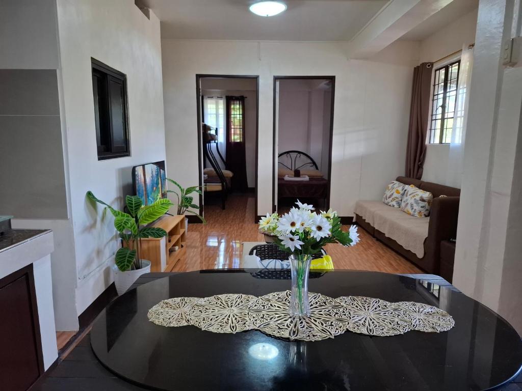 a living room with a vase of flowers on a table at Balay Degay Transient House in Baguio