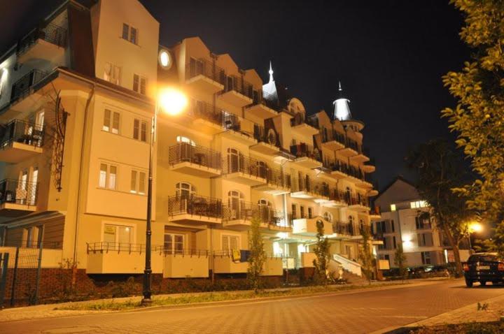 a large apartment building at night with a street at Apartament Regina Maris in Świnoujście