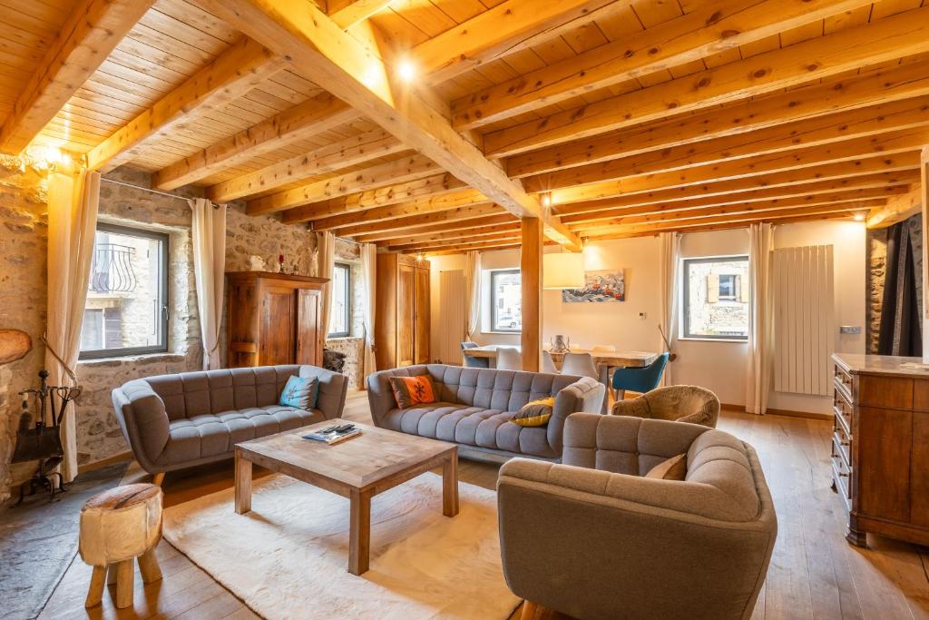 un soggiorno con divani e un tavolo di L’Écrin des Angles - Jacuzzi Sauna Hamman privé a Les Angles