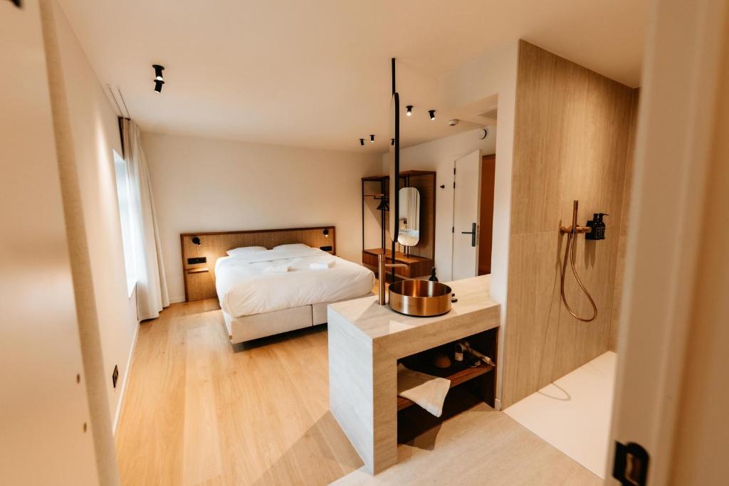 a bedroom with a bed and a bathroom with a shower at Alfred Hotel & Gastro Bar in Marche-en-Famenne