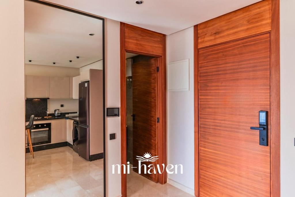 a wooden door to a kitchen in a house at Aura - 1 BR - Premium Apartment in Maarif