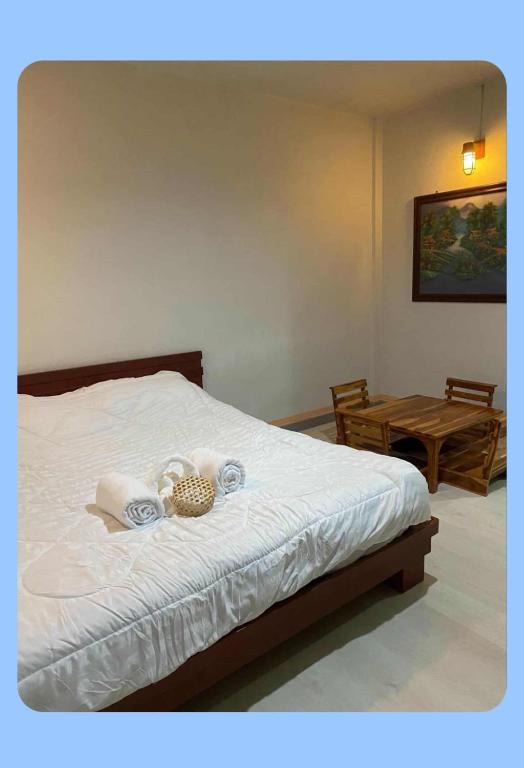 Ban Done Taoບ້ານ ດາວເຈົ້າ的一间卧室配有一张带毛巾和桌子的床