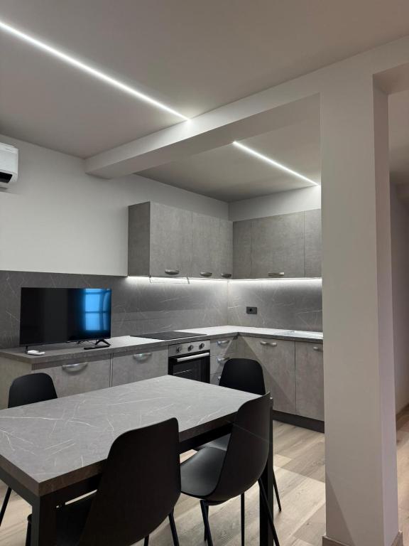una cucina con un tavolo e delle sedie di Lanzo Belvedere - Central Apartment a Lanzo Torinese