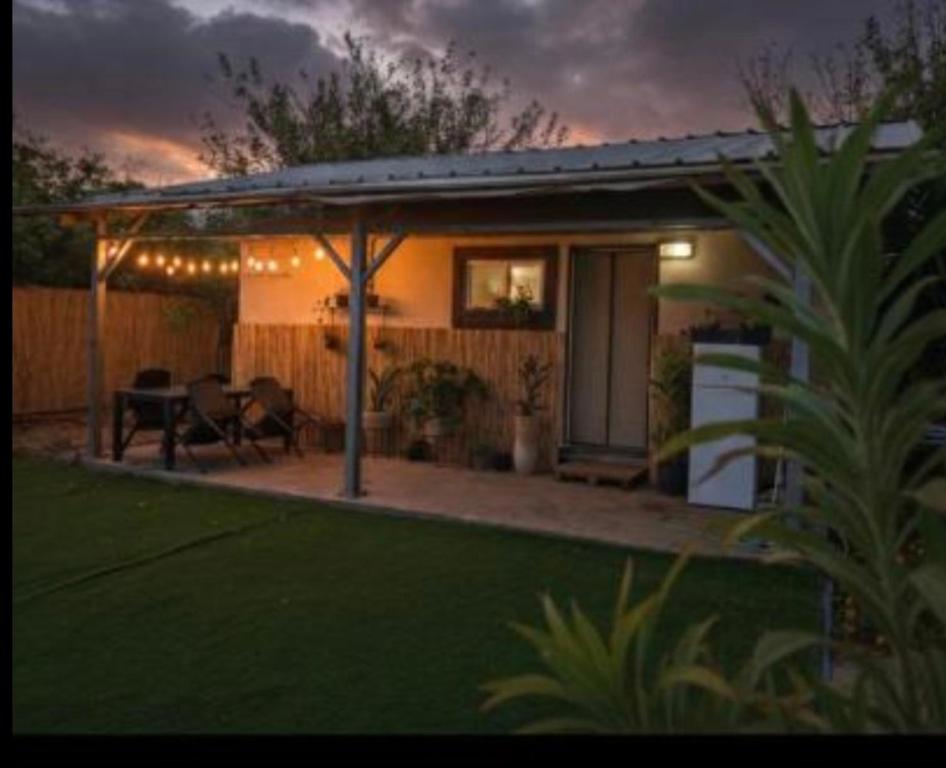 una casa con patio arredato con tavolo e sedie di בקתת המפל a Eli Ad