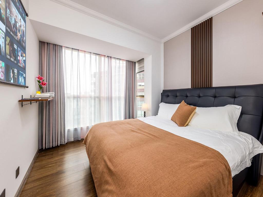 een slaapkamer met een groot bed en een groot raam bij Annie Apartment 3206 in Kunming