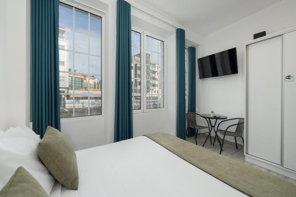 een slaapkamer met een groot bed en een tafel bij Residência Lord Freitas I by An Island Apart in Funchal