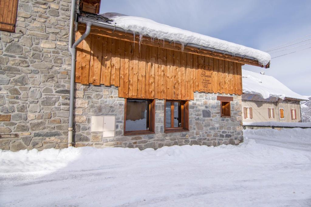 un bâtiment en pierre sous la neige dans l'établissement Chalet Pascal, à Valloire