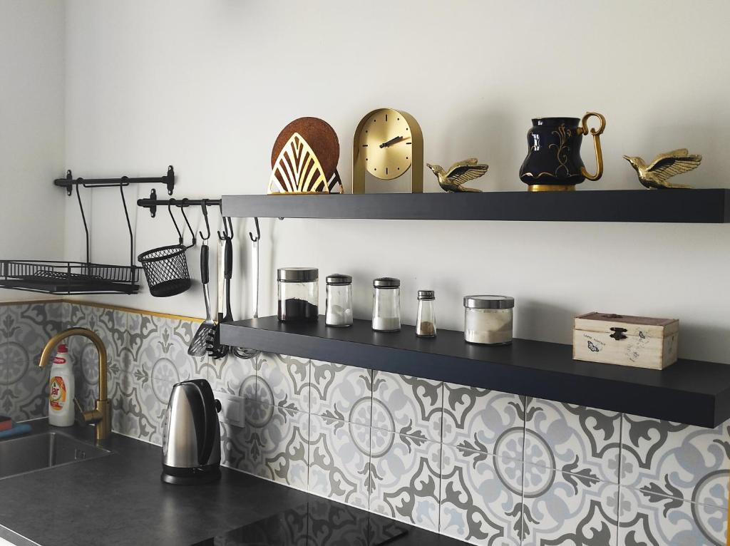 a kitchen with black shelves on the wall at Golden Home Törökbálint in Törökbálint