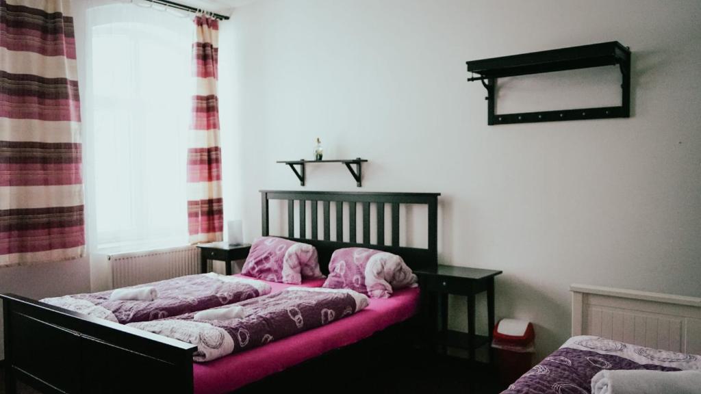 een slaapkamer met 2 bedden en roze lakens bij Penzion Stará škola Klíny in Klíny