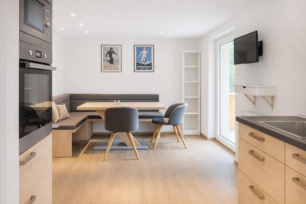 eine Küche mit einem Tisch und Stühlen in einer Küche in der Unterkunft Haus Dienten Appartements am Hochkoenig in Dienten am Hochkönig