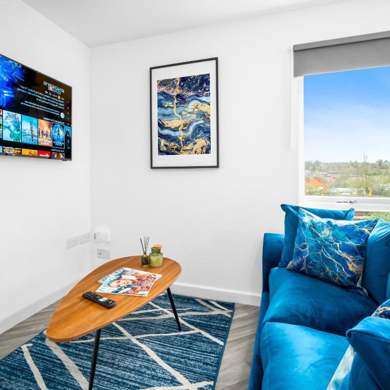 a living room with a blue couch and a table at Modern Two Bed Apartment - Sleeps 3 - WiFi & Parking Included 57C in Sleightholme