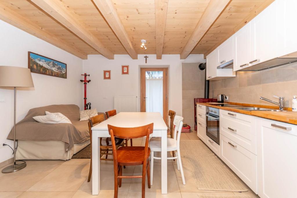 una cucina e una sala da pranzo con tavolo e sedie di Ciasa al Caselo a Falcade
