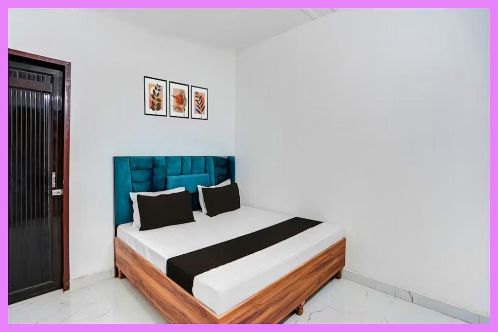 a bedroom with a bed with a blue headboard at Hotel Kavmira Premium Inn in Puri