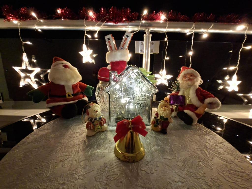 a group of santa clauses on a table with christmas lights at Apartman TRI KRALJA 2 in Banja Koviljača