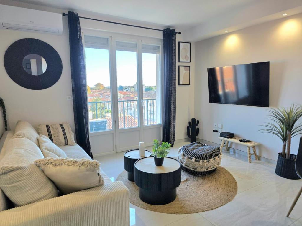 een woonkamer met een bank en een groot raam bij Appartement moderne, Centre Perpignan in Perpignan