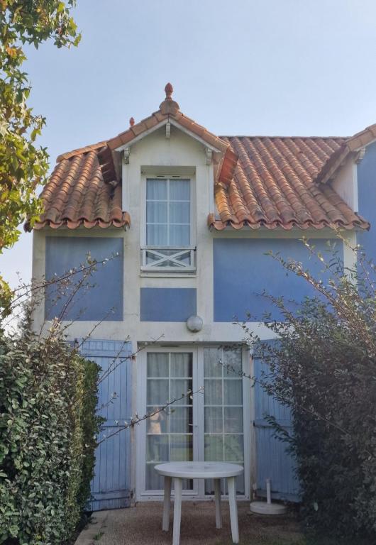 a blue house with a picnic table in front of it at Maisonnette duplex 4 pers proche mer et golf in Talmont