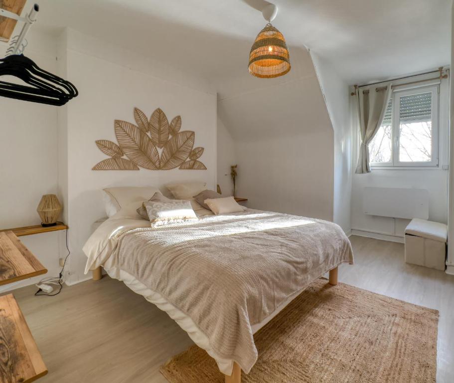 um quarto com uma cama grande e uma janela em L'Oscar Imperial em Compiègne