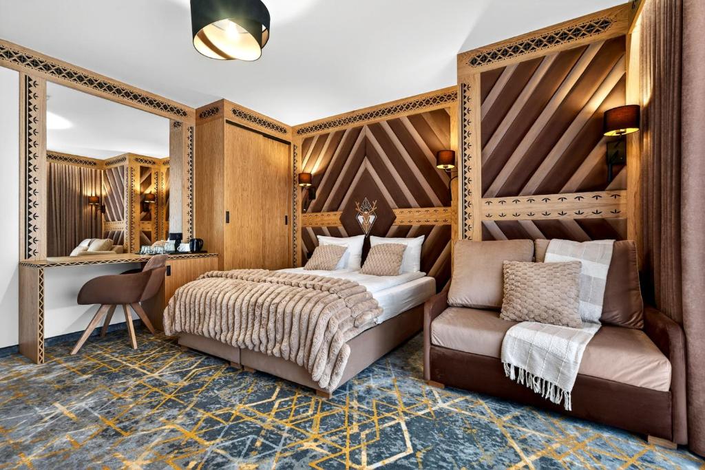 a bedroom with a bed and a chair at Grand Regle Resort & SPA in Poronin