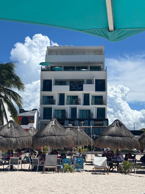 ein Gebäude am Strand mit Stühlen und Sonnenschirmen in der Unterkunft Simple y Luxury in Progreso