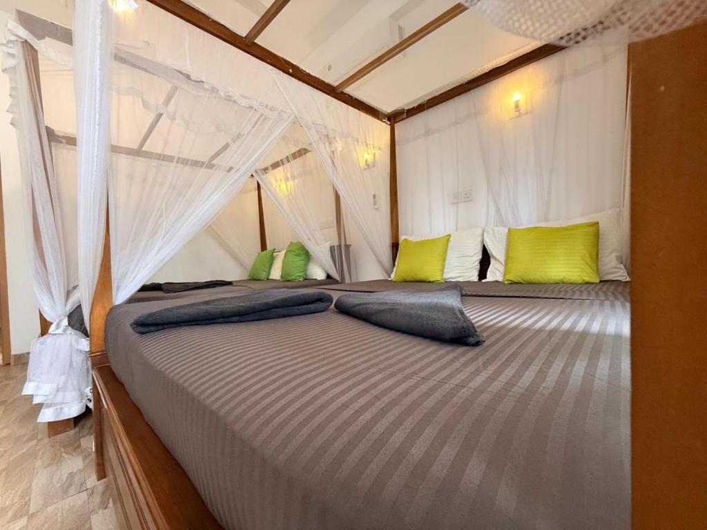 En eller flere senge i et værelse på Pearl Deluna Resort Mirissa