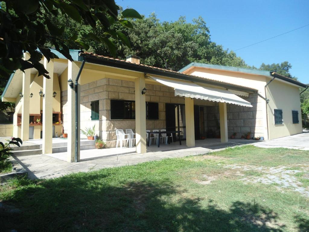 ein Haus mit einer Veranda mit einem Tisch und Stühlen in der Unterkunft Quinta do Olival - Douro Valley in Sande