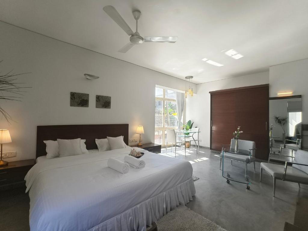 ein Schlafzimmer mit einem großen weißen Bett und ein Wohnzimmer in der Unterkunft Urban Opulence in Bangalore