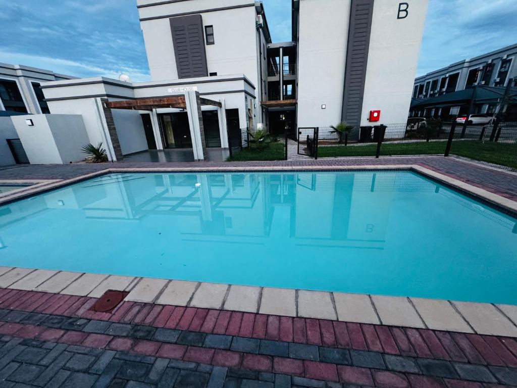een groot blauw zwembad voor een gebouw bij The Nook in Gaborone