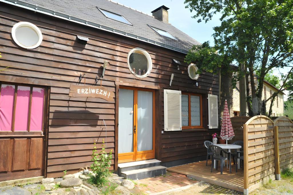 ein Holzhaus mit einem Tisch davor in der Unterkunft Gîte Erziwezh in La Porte