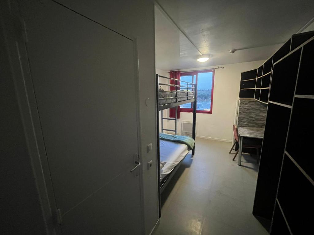 加尔热莱戈内塞HOTEL et RESIDENCE GARGES STALINGRAD的有两张双层床和一张书桌的房间