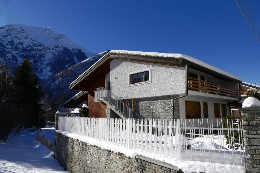 een huis met een wit hek in de sneeuw bij Villa Rostagno in Entracque