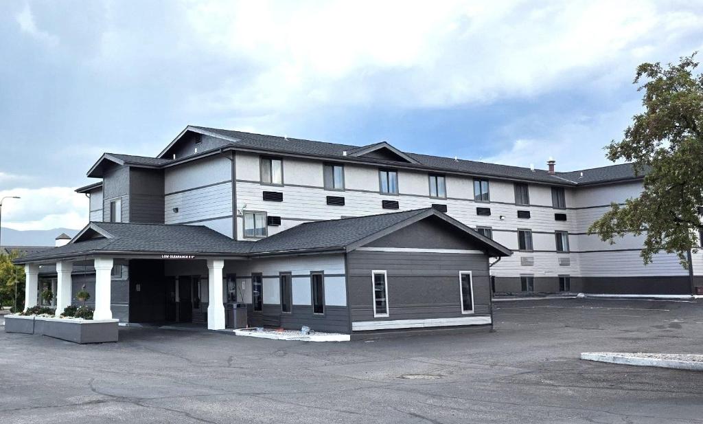 un gran edificio blanco con aparcamiento en Big Sky Inn, en Missoula