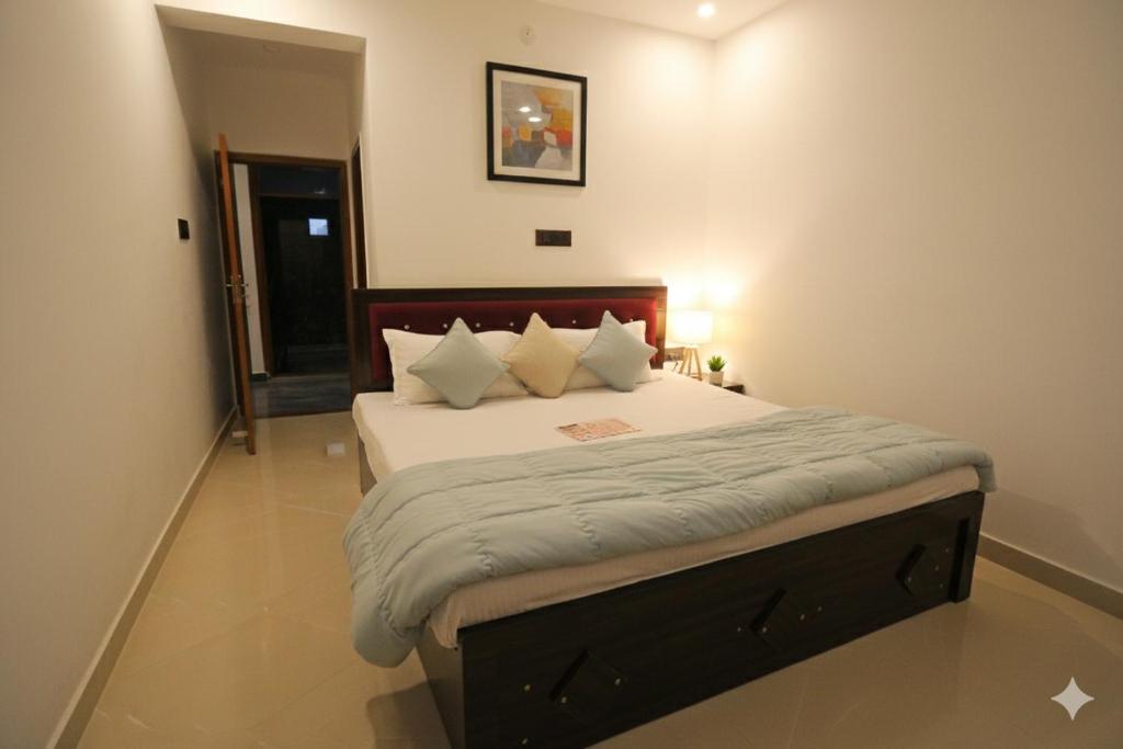 een slaapkamer met een bed met witte lakens en kussens bij Monishka Palace in Faizābād