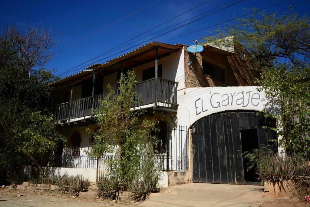 un bâtiment blanc avec une porte devant dans l'établissement El Garaje Hostal, à Taganga
