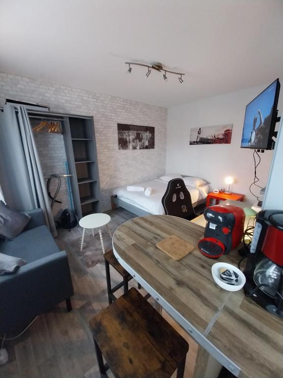 un soggiorno con un tavolo e un divano di Studio Beauséjour a Niort